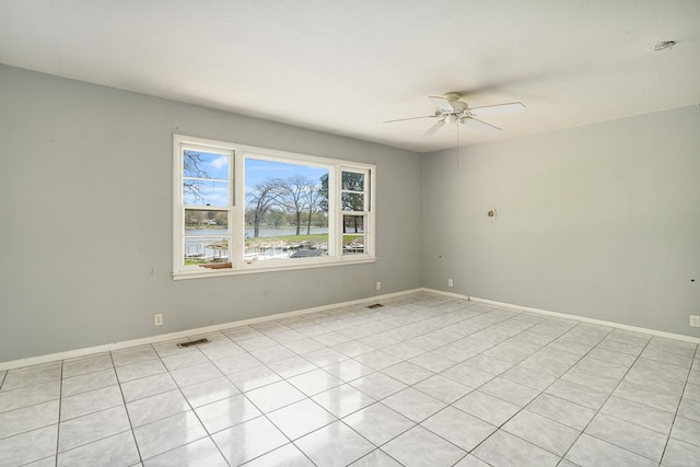 spare room with ceiling fan, baseboards, visible vents, and a water view
