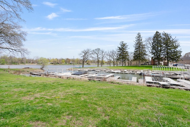 view of dock with a yard and a water view