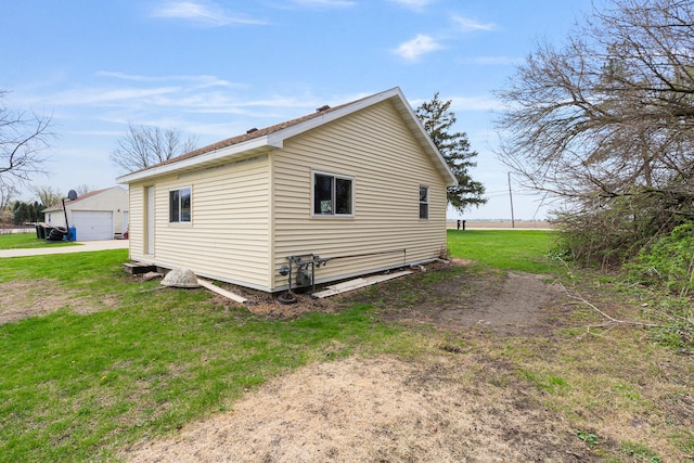 view of property exterior featuring a lawn, an outdoor structure, and a garage