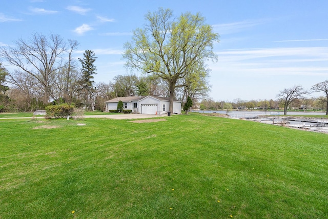 view of yard featuring driveway and a water view