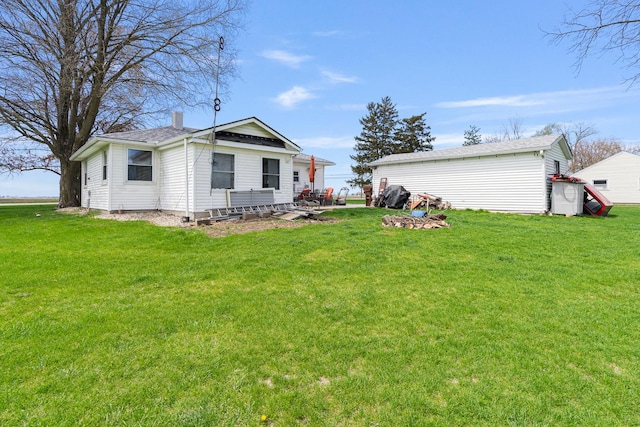 rear view of property featuring a lawn and a chimney