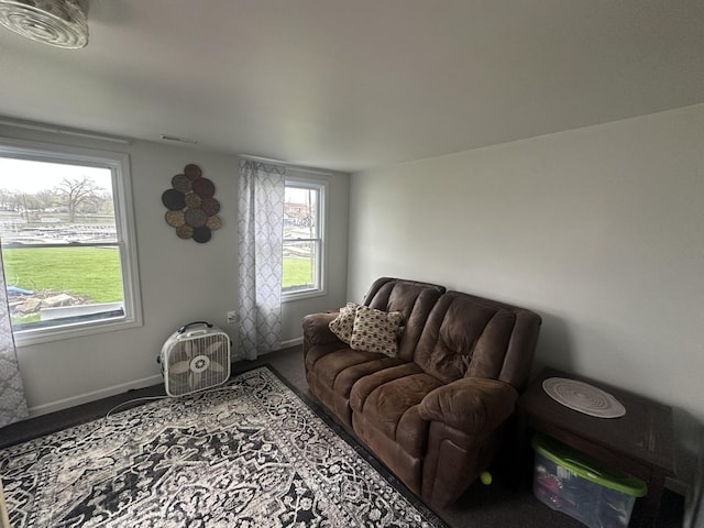 carpeted living area featuring visible vents and baseboards