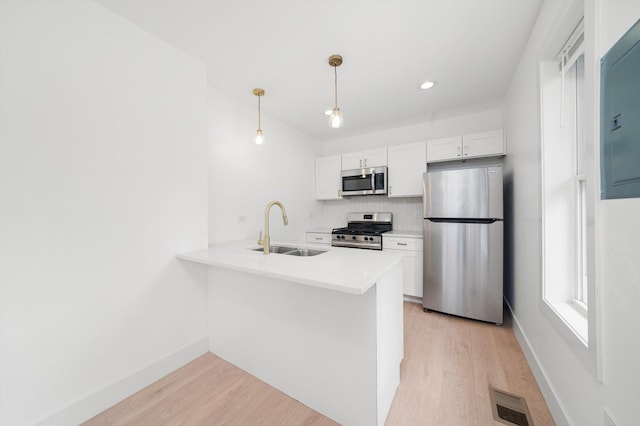 3246 S Normal Ave, Chicago, IL 60616 - kitchen with appliances with stainless steel finishes, light wood-style floors, a peninsula, white cabinets, and recessed lighting
