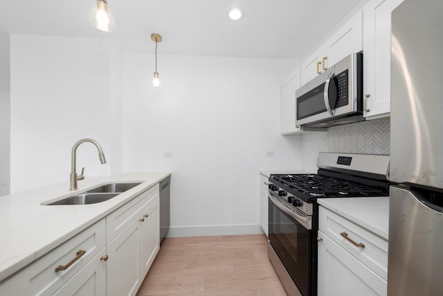 3246 S Normal Ave, Chicago, IL 60616 - kitchen featuring stainless steel appliances, decorative backsplash, light wood-style flooring, white cabinets, and hanging light fixtures