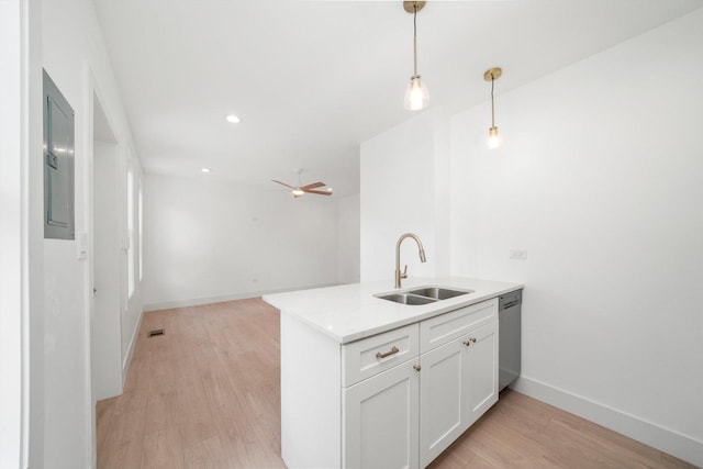 3246 S Normal Ave, Chicago, IL 60616 - kitchen with stainless steel dishwasher, light wood-type flooring, pendant lighting, white cabinets, and light countertops