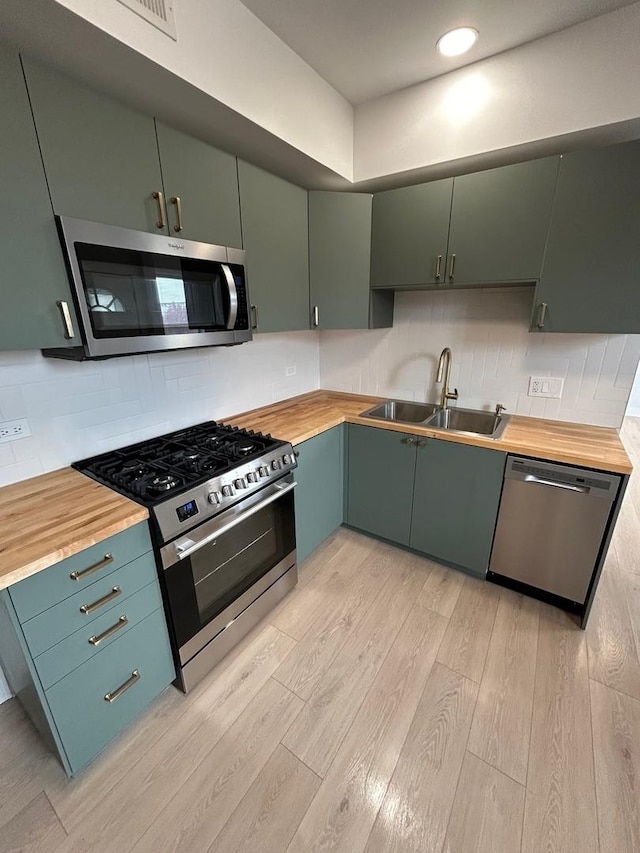 3246 S Normal Ave, Chicago, IL 60616 - kitchen featuring appliances with stainless steel finishes, wood counters, light wood-style flooring, tasteful backsplash, and recessed lighting