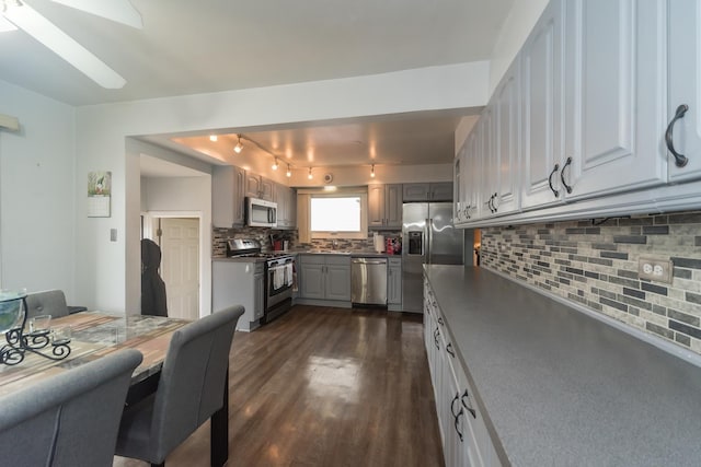 8212 N Ozanam Ave, Niles, IL 60714 - kitchen featuring track lighting, backsplash, appliances with stainless steel finishes, gray cabinetry, and dark wood-type flooring