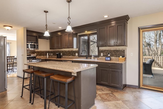 kitchen featuring backsplash, plenty of natural light, stainless steel appliances, and a sink
