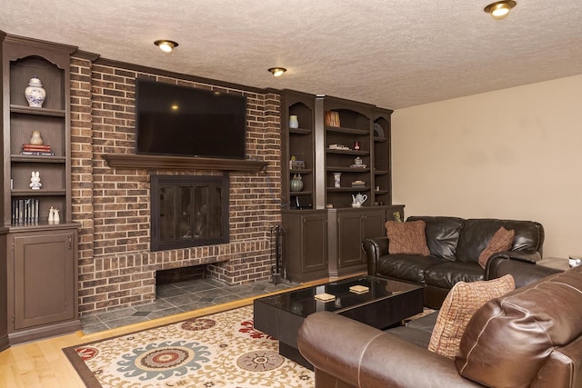 living area featuring a fireplace, wood finished floors, and a textured ceiling