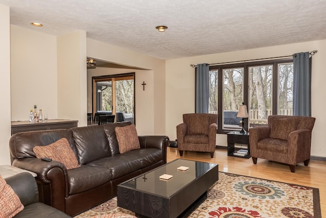 living room featuring recessed lighting, light wood-style flooring, and a textured ceiling