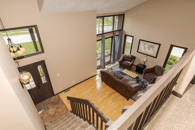 living room with baseboards, a wealth of natural light, high vaulted ceiling, and visible vents