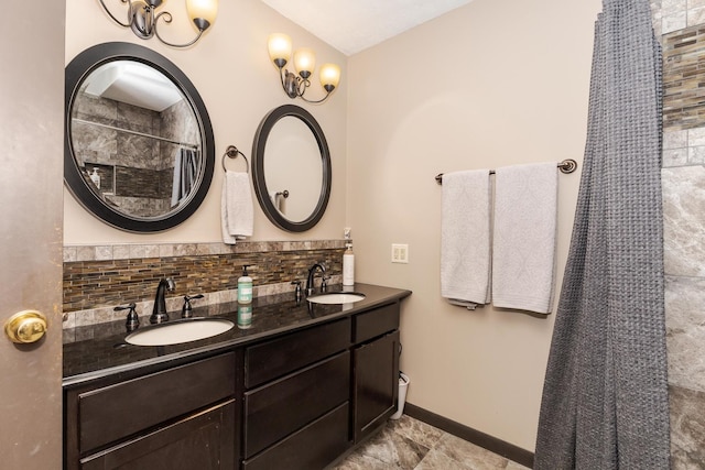 full bath featuring a tile shower, double vanity, baseboards, and a sink