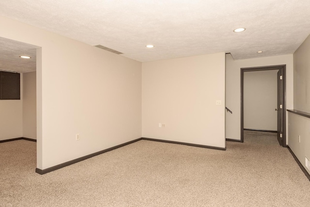 spare room featuring baseboards, light carpet, visible vents, and recessed lighting