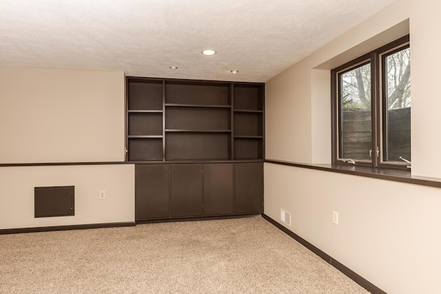 unfurnished room featuring a textured ceiling, baseboards, carpet, and recessed lighting