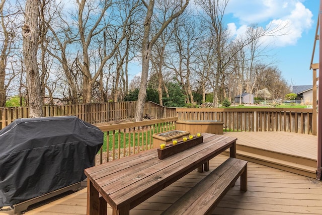 wooden deck featuring a fenced backyard and a grill
