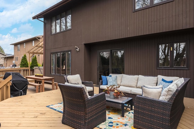 wooden terrace with grilling area and an outdoor living space