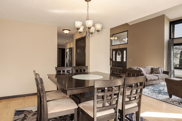 dining area with hardwood / wood-style flooring and an inviting chandelier