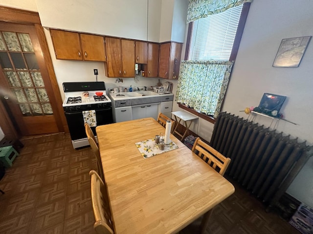 kitchen with range with gas cooktop, radiator, and brown cabinetry