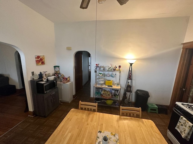 dining area featuring ceiling fan and arched walkways