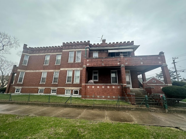 view of front of property featuring brick siding and a fenced front yard
