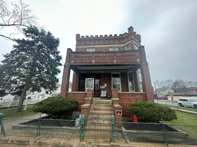 view of front facade with brick siding and a fenced front yard