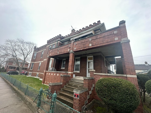 view of front of property with brick siding and fence