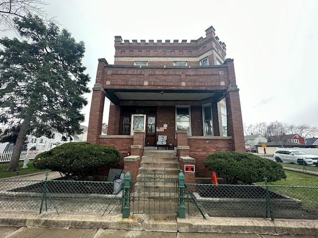 view of front of home with brick siding and a fenced front yard