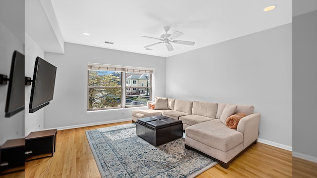 living room featuring a ceiling fan, light wood-style floors, baseboards, and recessed lighting