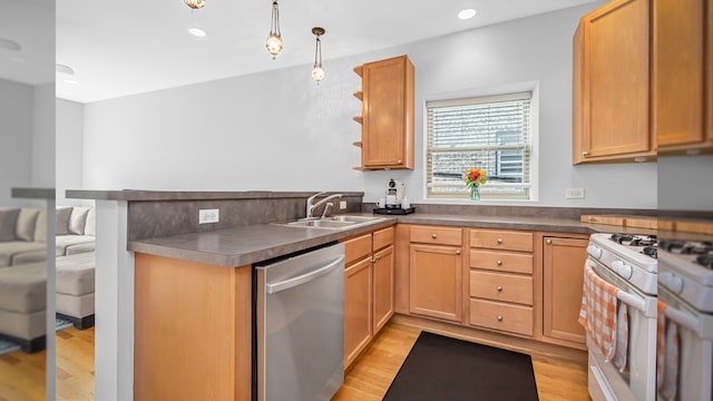 kitchen featuring white range with gas cooktop, stainless steel dishwasher, a peninsula, a sink, and light wood-type flooring