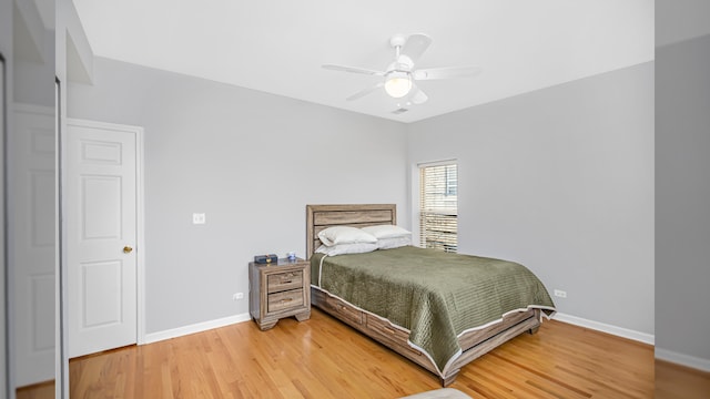bedroom with light wood-style flooring, baseboards, and ceiling fan