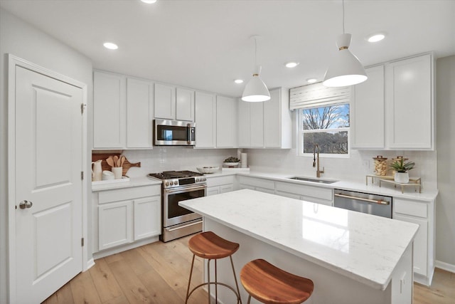 730 Cloverleaf Dr, Marengo, IL 60152 - kitchen with stainless steel appliances, white cabinetry, a sink, and a kitchen island