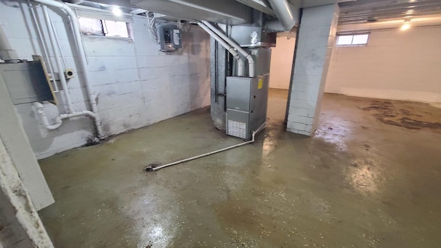 basement with a wealth of natural light, heating unit, and electric panel