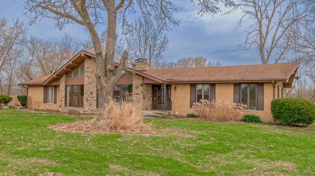 3515 Partridge Ln, Belvidere, IL 61008 - view of front facade with a chimney, a front lawn, brick siding, and a shingled roof