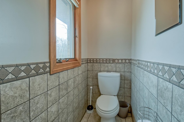 3515 Partridge Ln, Belvidere, IL 61008 - half bath with tile walls, tile patterned floors, toilet, and wainscoting