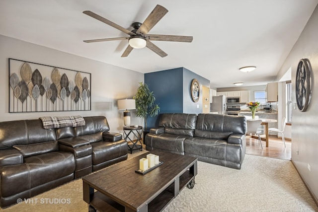 living area featuring light wood-style floors and a ceiling fan