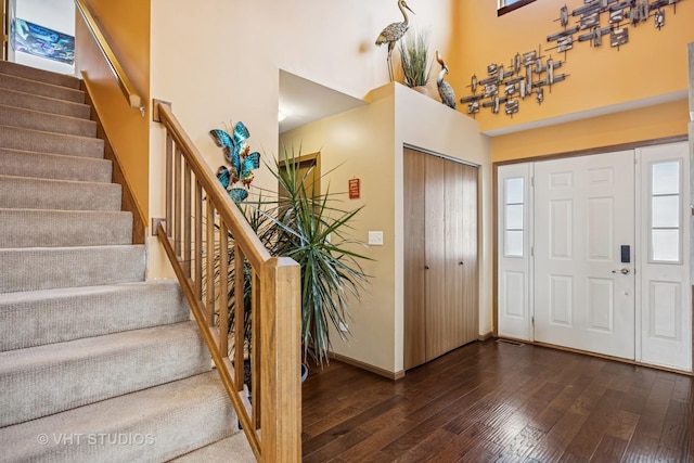 entryway with baseboards, a high ceiling, stairway, and dark wood finished floors