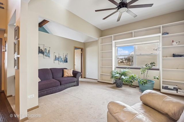 carpeted living area featuring lofted ceiling, baseboards, and ceiling fan