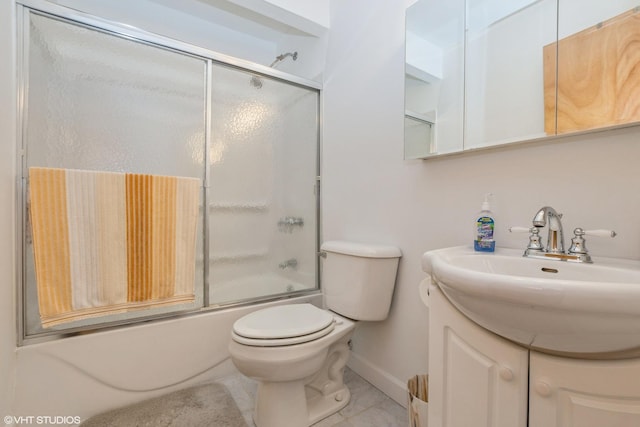 full bathroom with tile patterned floors, toilet, vanity, bath / shower combo with glass door, and baseboards