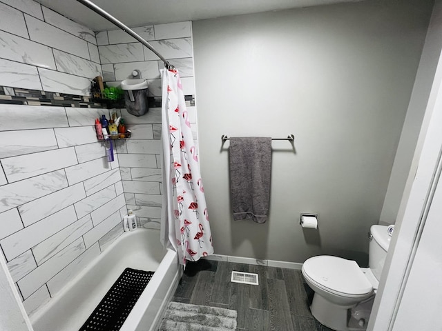 bathroom featuring toilet, visible vents, baseboards, wood finished floors, and shower / bathtub combination with curtain