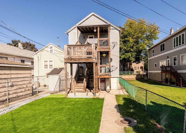 back of house featuring stairway, a fenced backyard, a yard, a shed, and an outdoor structure