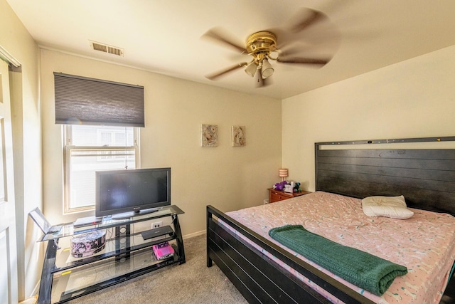 carpeted bedroom with visible vents, a ceiling fan, and baseboards