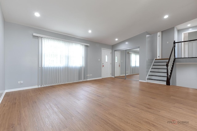 1680 Bicek Dr, Hoffman Estates, IL 60192 - unfurnished living room with stairway, healthy amount of natural light, wood finished floors, recessed lighting, and vaulted ceiling