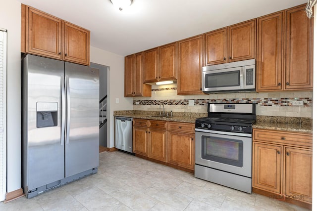 1680 Bicek Dr, Hoffman Estates, IL 60192 - kitchen with stainless steel appliances, brown cabinetry, decorative backsplash, and dark stone counters