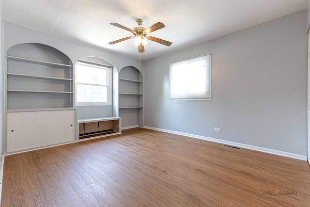 1680 Bicek Dr, Hoffman Estates, IL 60192 - empty room featuring wood finished floors, built in shelves, and a ceiling fan