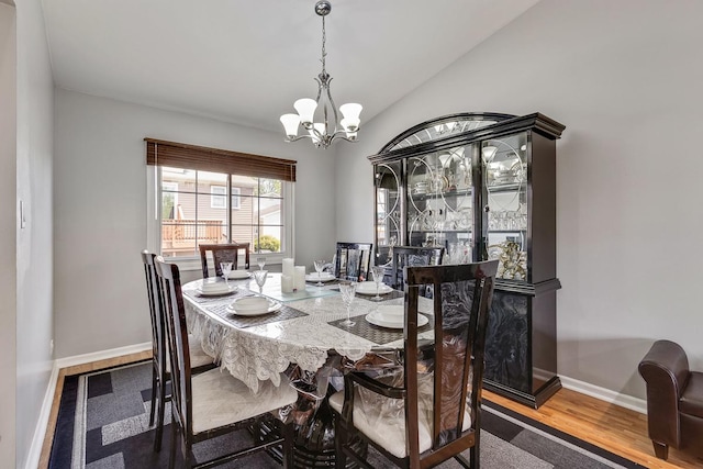 1680 Bicek Dr, Hoffman Estates, IL 60192 - dining area with a chandelier, lofted ceiling, and wood finished floors