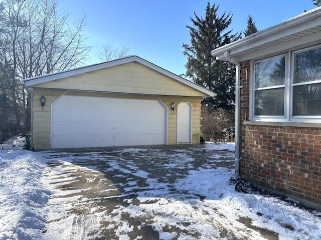 snow covered garage with a detached garage