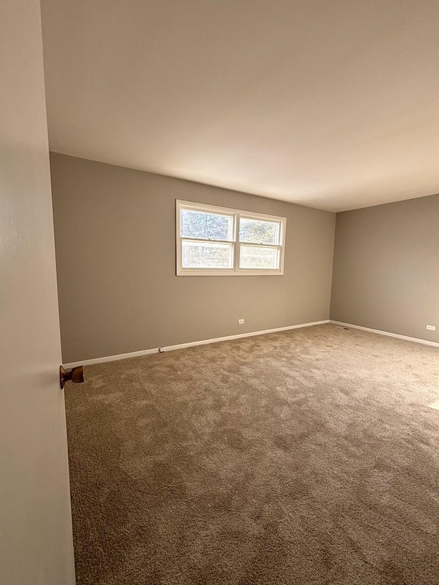 unfurnished room with baseboards and carpet floors