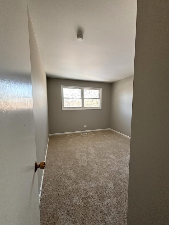 empty room featuring baseboards and carpet