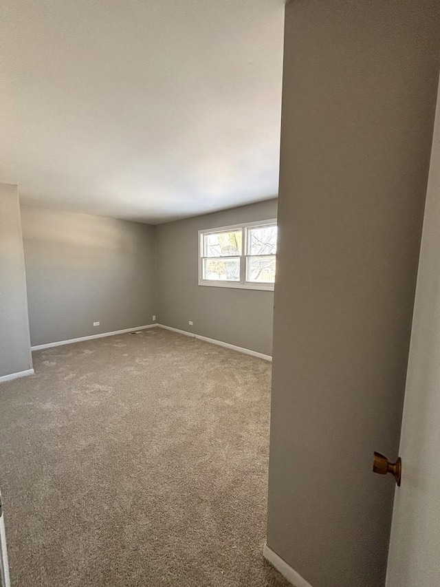 unfurnished room featuring baseboards and carpet