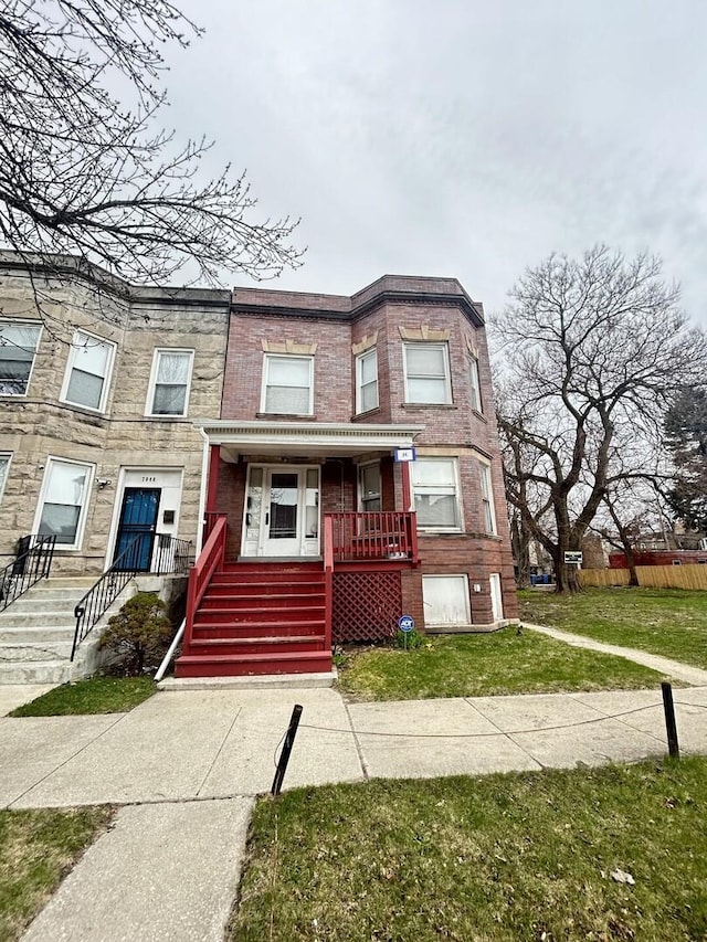 7038 S Vernon Ave, Chicago, IL 60637 - townhome / multi-family property with covered porch, a front lawn, and stone siding